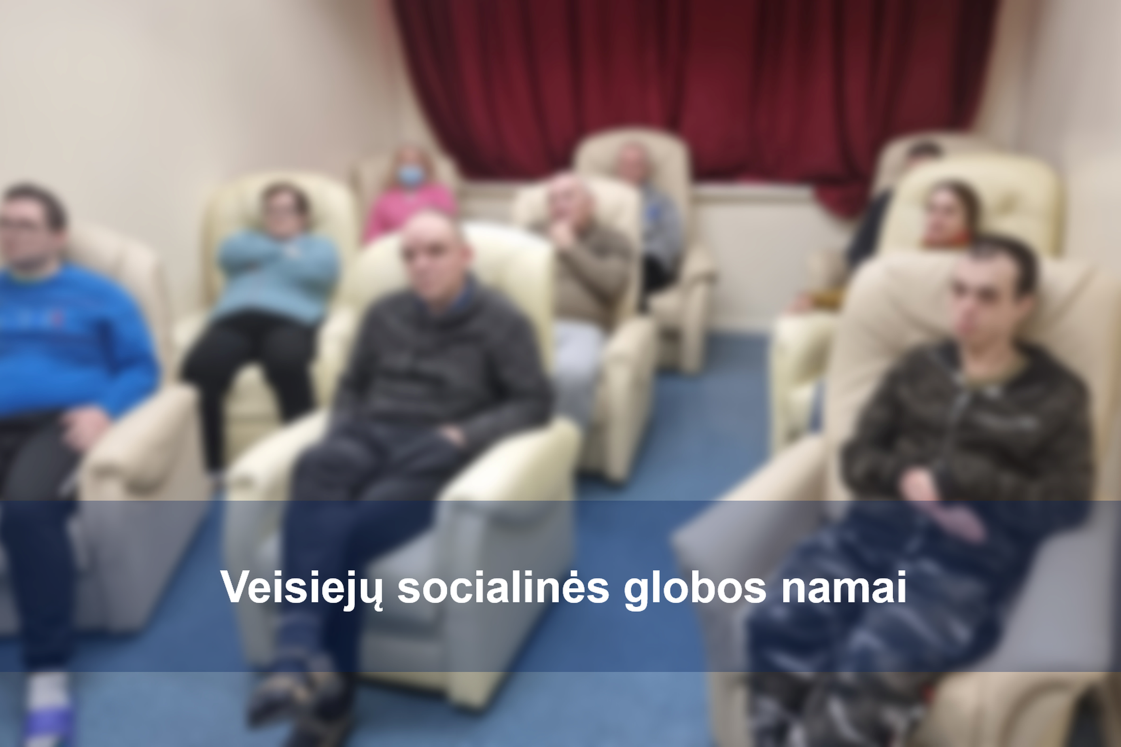 Veisiejų socialinės globos namų gyventojai patogiai klausosi paskaitos apie Vilniaus pilis. Nuotraukos priekyje įstaigos pavadinimas.