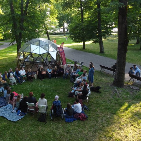 Vakarėjant būrys moterų dainavo Pilių parke, prie kupolo.