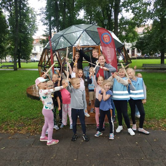Vaikai, iškėlę medinius kalavijus šalia Vilniaus pilių kupolo, pozuoja nuotraukai. 
