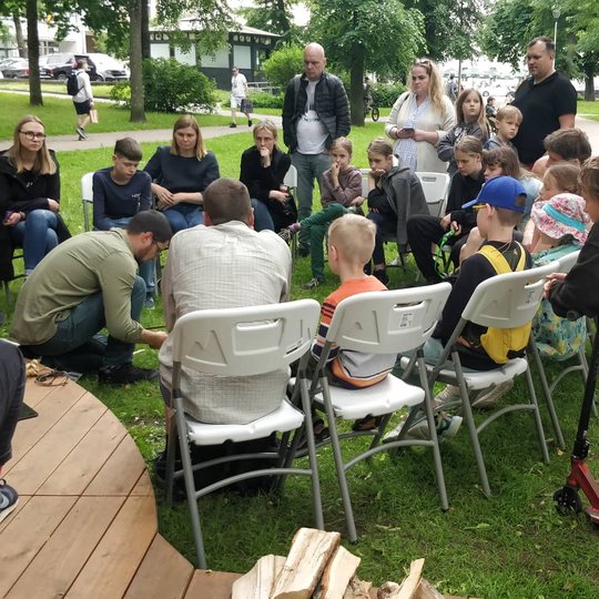 Archeologas Algirdas Kalinauskas šalia Vilniaus pilių kupolo rodo susirinkusiems žmonėms, kaip galima įskelti ugnį.