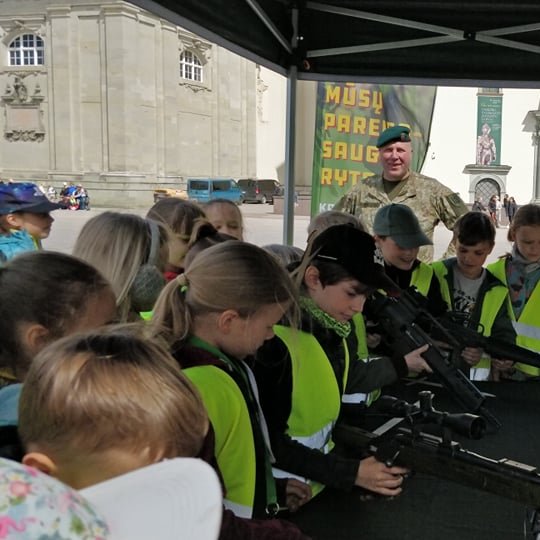 Vaikai šalia Gedimino paminklo apžiūrinėję modernius ginklus, kuriuos pristato krašto apsaugos sąvanoriai. 