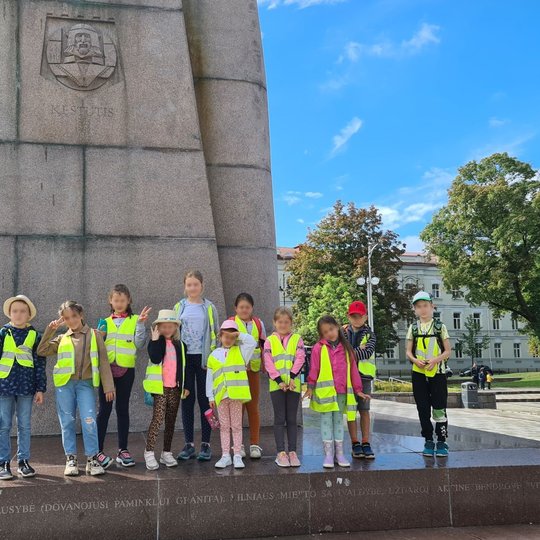 Visi pozuoja prie kunigaikščio Gedimino paminklo.