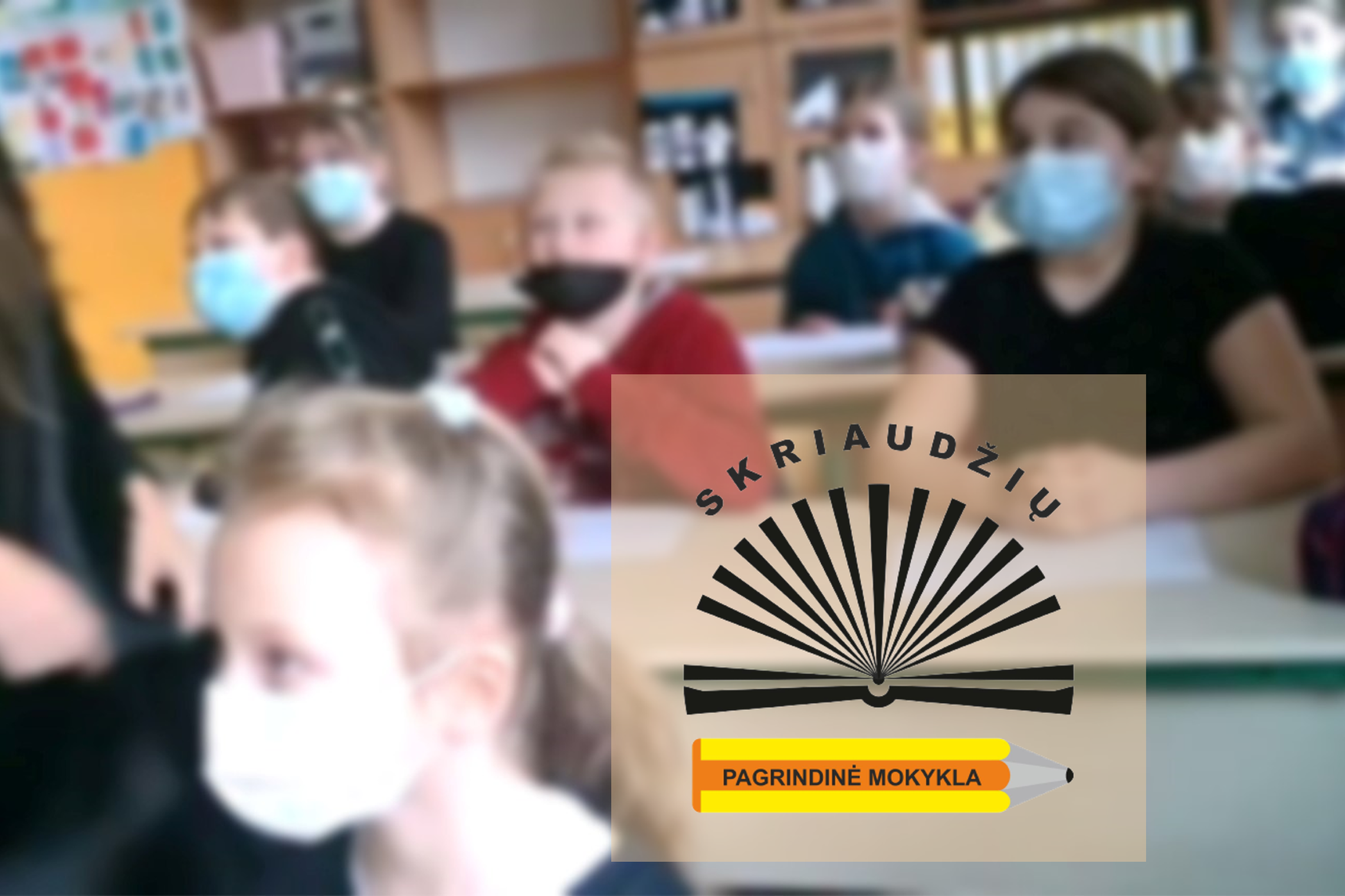 Mokiniai, su medicininėm kaukėm, klasėje. Nuotraukos apačioje Skriaudžių pagrindinės mokyklos logotipas.