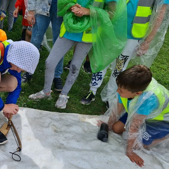 Apsišarvavus lietpalčiais, toliau bandyta kurti ugnį su pagaliuku ir lentele.