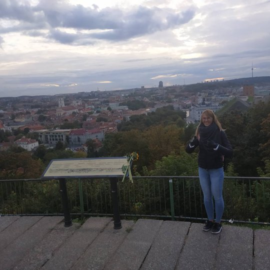 Ekskursijos dalyvė pozuoja nuotraukai nuo Trijų Kryžių kalno.