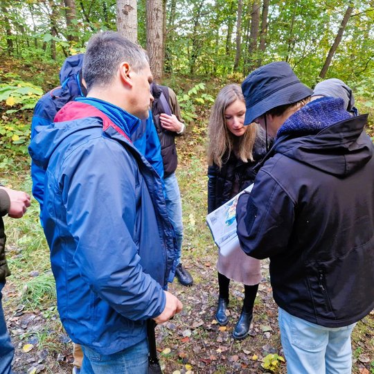 Gidas rodo papildomą medžiagą ekskursijos dalyviams ant Bevardžio piliakalnio.
