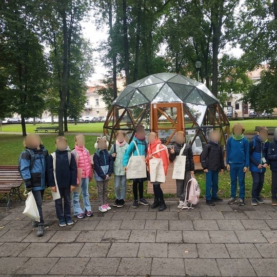 Šiaurės Licėjaus ketvirtokai pozuoja nuotraukai, priešais Vilniaus pilių kupolą.