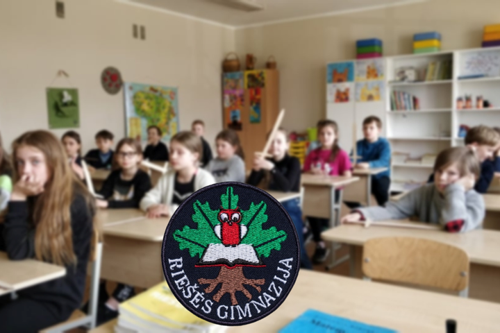 Mokiniai su mediniai kalavijais. Nuotraukos priekyje Riešės gimnazijos logotipas.