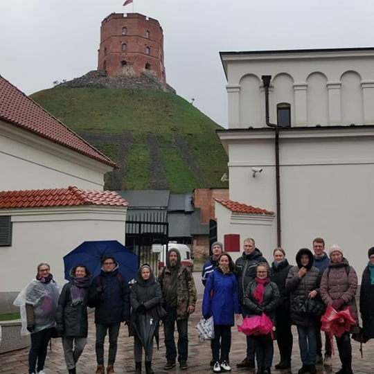 Ekskursijos dalyviai Valdovų rūmų vidiniame kieme. Jiems už nugarų matosi Aukštutinė pilis. 