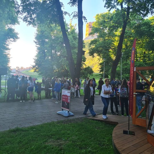 Vilniaus pilių kupolas iš šono. Matosi gausi žmonių minia ir Gedimino kalnas tolumoje. 