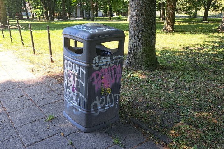 Gausiai išdažyta dažais ir terlionėmis šiukšliadėžė, esanti Pilių parke.