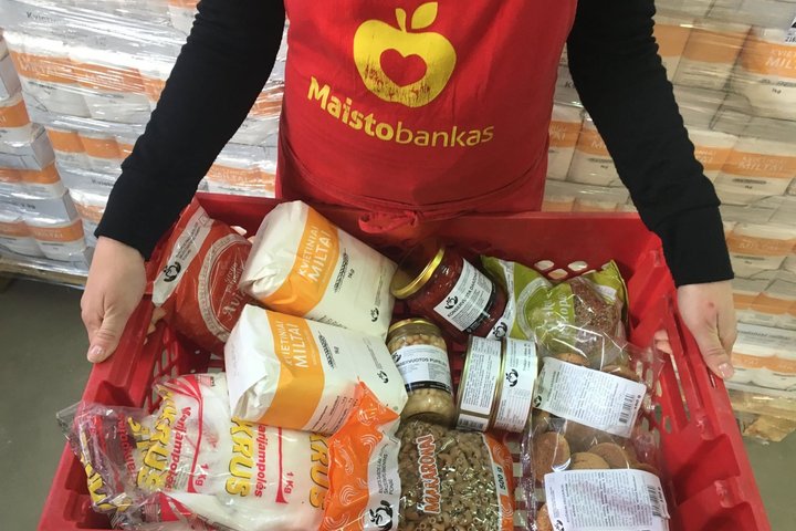 Miasto banko savanoris laiko dėžę, kuri pilna maisto produktų.