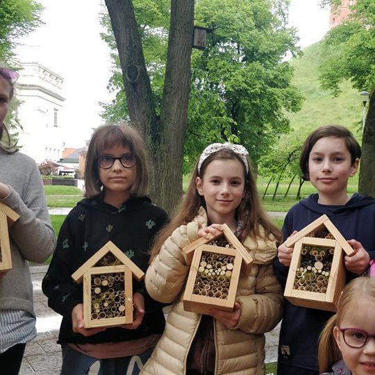 Vaikai šalia Vilniaus pilių kupolo. Rankose vaikai laiko užpildytas vamzdžių pilys.
