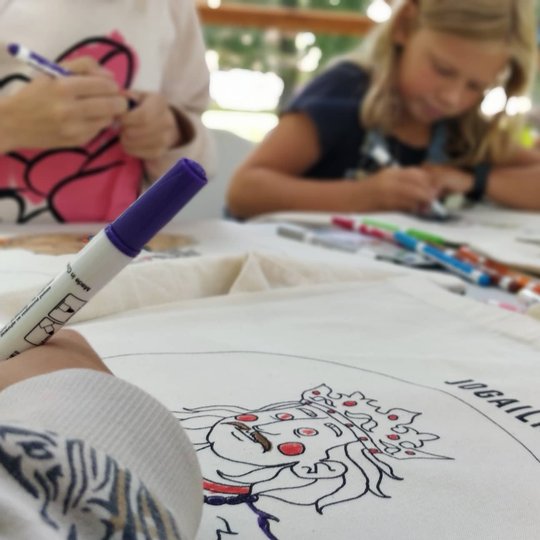 Vilniaus pilių kupole vaikai spalvoja maišelius.