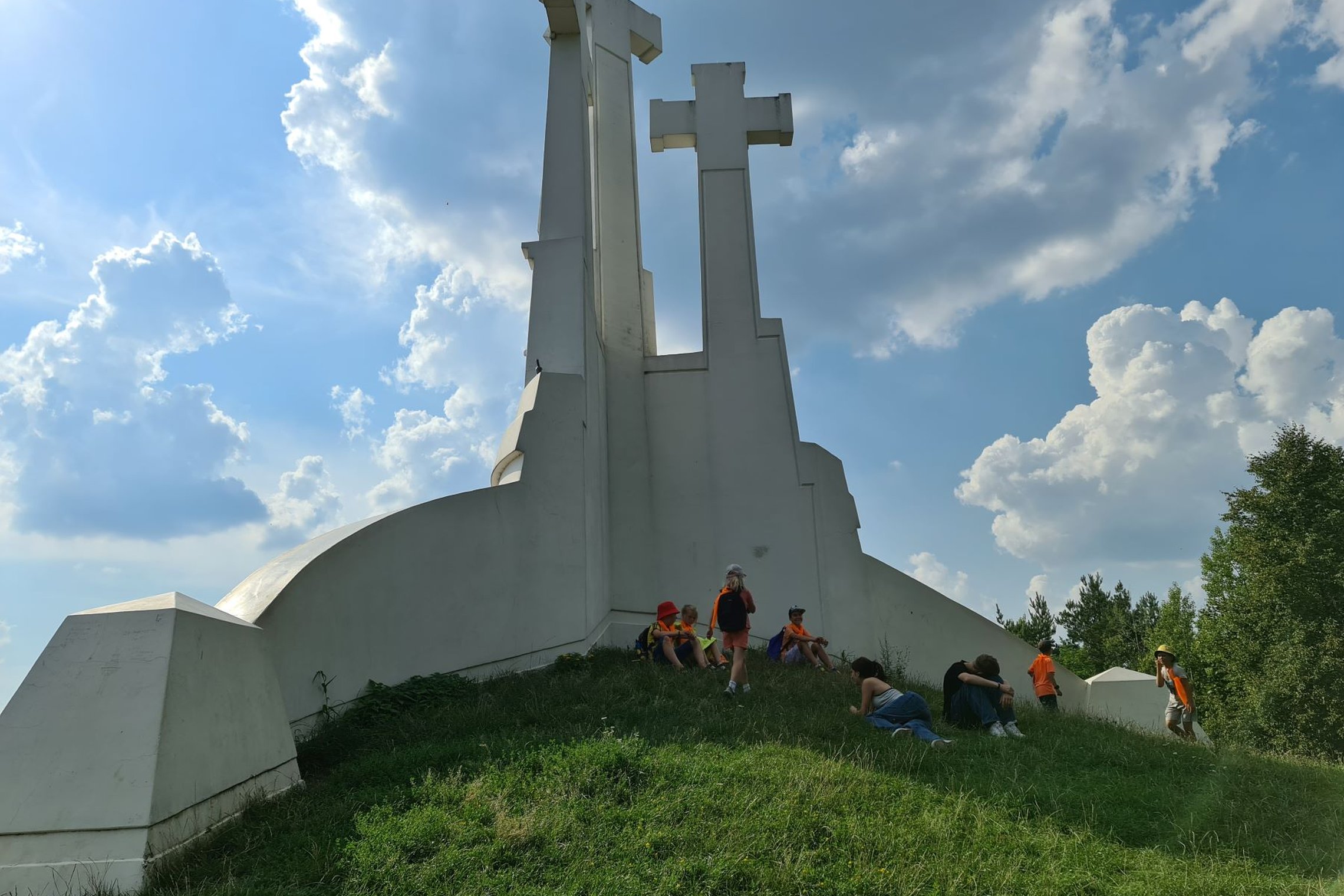 Vaikai slepiasi pavėsyje, prie Trijų kryžių paminklo.