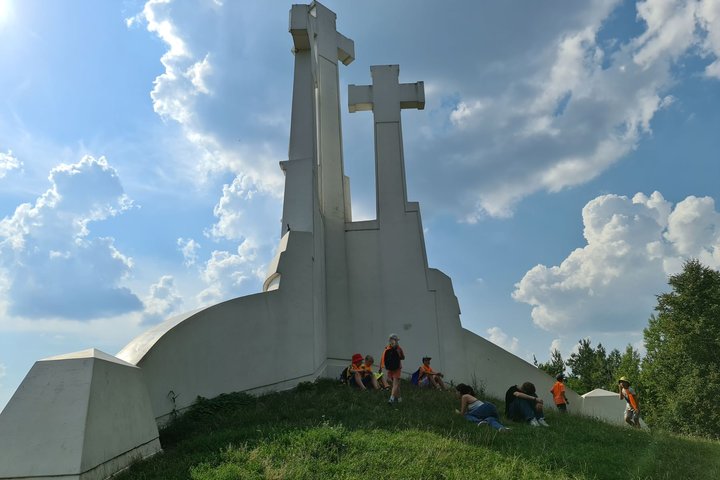 Vaikai slepiasi pavėsyje, prie Trijų kryžių paminklo.