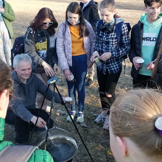Jaunieji turistai ant Stalo kalno geria arbatą iš katilo.