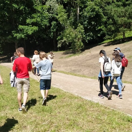 Moksleiviai atviroje vietoje leidžiasi nuo Stalo kalno. 
