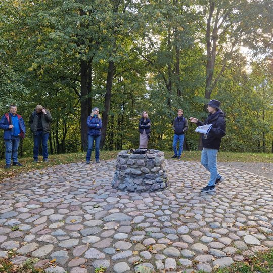 Ekskursijos dalyviai klausosi gido ant Gedimino kapo kalno. 