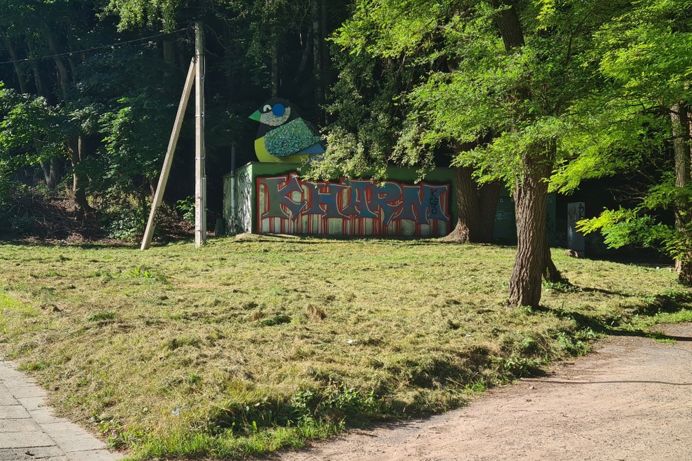 „Vilniaus šilumos tinklų“ siurblinė, su ant sienos išpaišytu grafyčiu. Nuotrauka daryta saulėtos dienos metu.