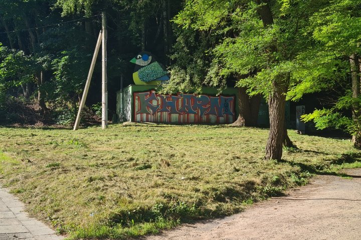 „Vilniaus šilumos tinklų“ siurblinė, su ant sienos išpaišytu grafyčiu. Nuotrauka daryta saulėtos dienos metu.