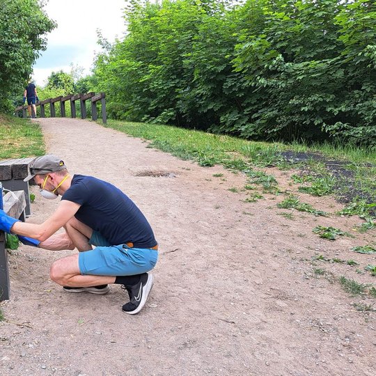 Savanoris stengėsi nuvalyti dažų pėdsakus ir nuo medžio. Valomas Altanos kalno lauko suolas.
