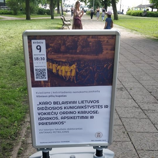 Renginio afiša stende, šalia Vilniaus pilių kupolo.