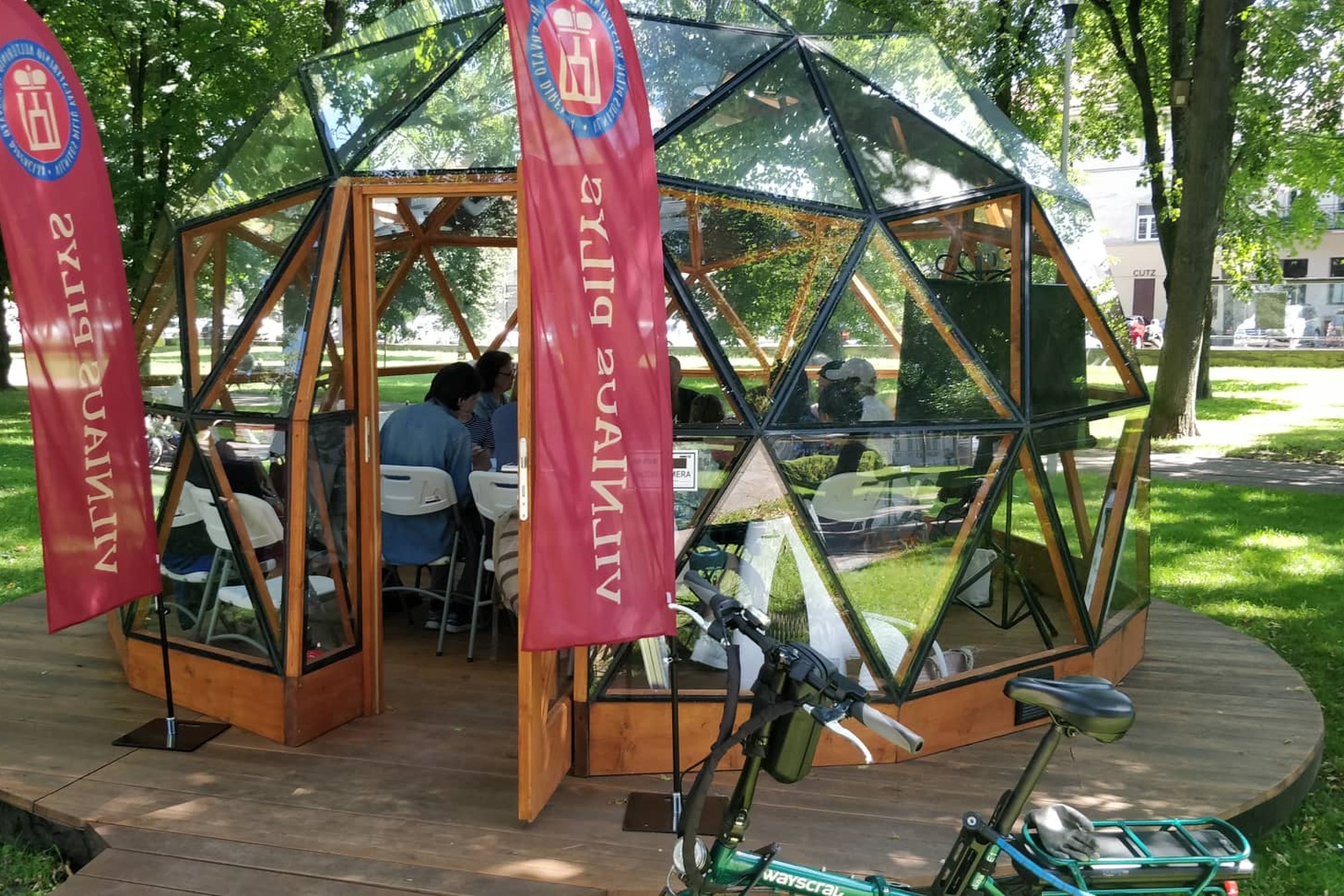 Vilniaus pilių kupolas iš laiko, atviromis durimis. Jame matosi sėdintis žmonės.