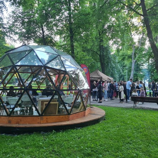 Vilniaus pilių kupolas iš lauko. Viduje matosi šauliai, toliau už kupolo palapinė ir šalia jos esantys žmonės.
