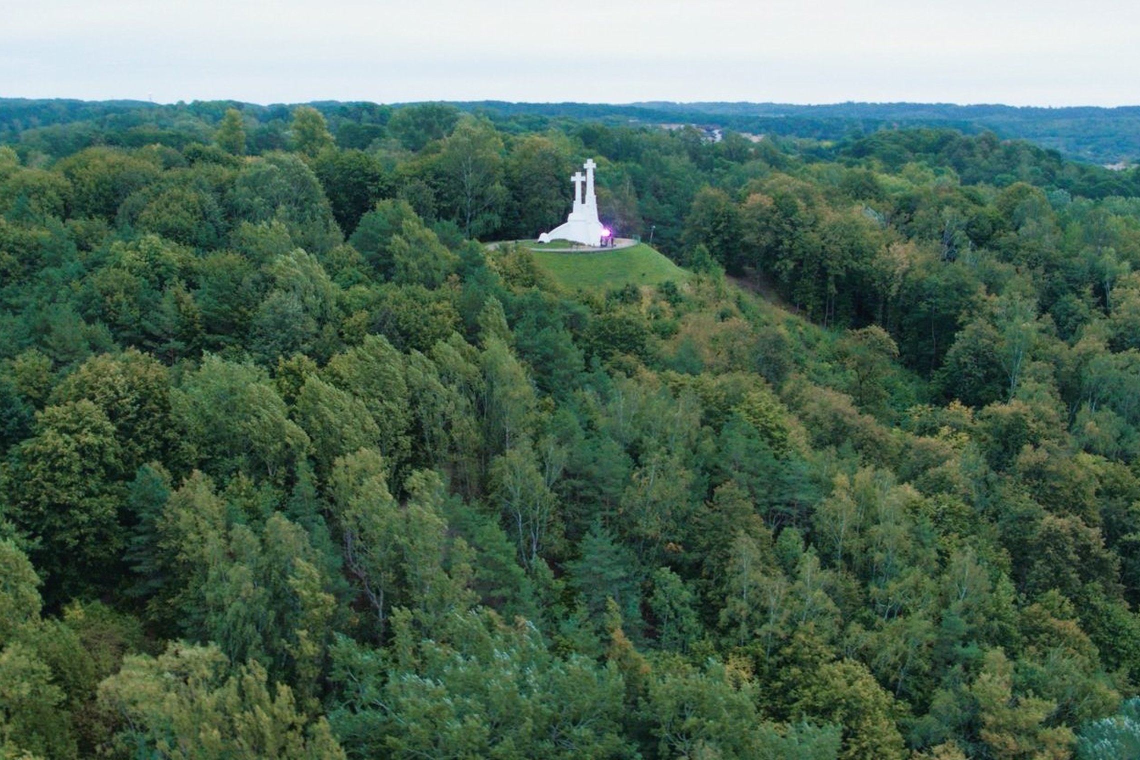 Trijų Kryžių kalva. Matosi Trijų Kryžių paminklas ir aplink gausus medžiai. 