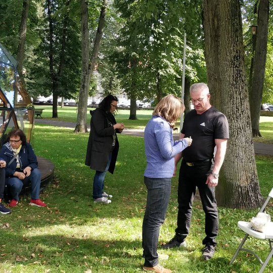 Edukacijos dalyviai bando įžiebti ugnį šalia Vilniaus pilių kupolo.
