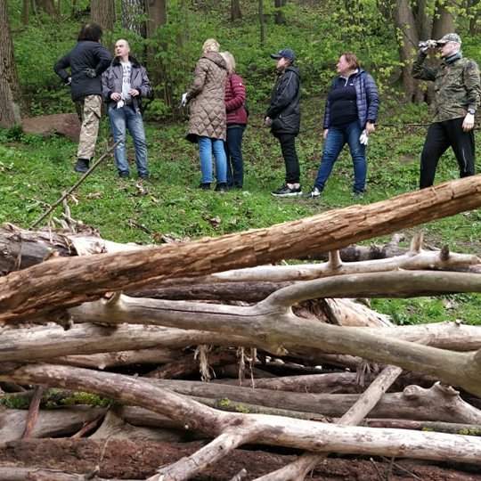 Vidaus reikalų ministerijos darbuotojai stovi ant tako. Nuotraukos apačioje šakų krūva.