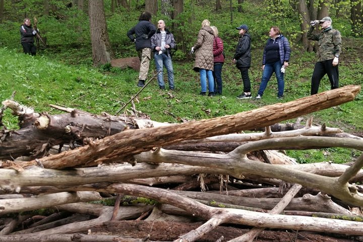Vidaus reikalų ministerijos darbuotojai stovi ant tako. Nuotraukos apačioje šakų krūva.