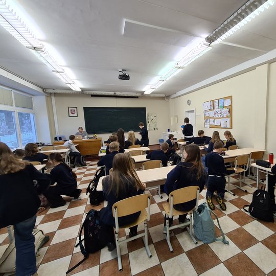 Mokiniai susėdo į klasės suolus. Vyksta istorijos pamoka.