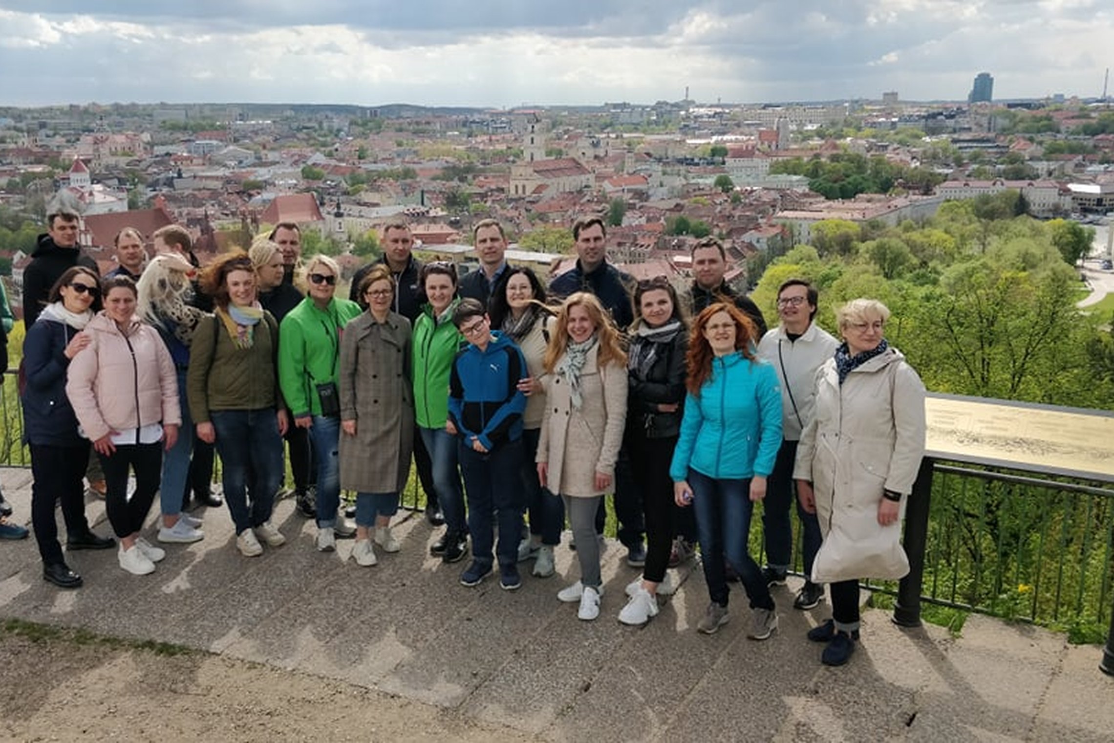 Ekskursijos dalyviai. Jiems už nugarų Vilniaus panorama nuo Trijų Kryžių kalno.