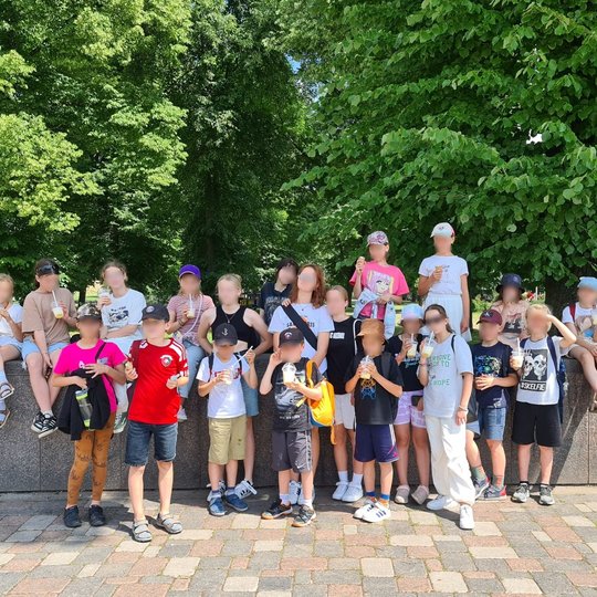 Gausi vaikų kompanija ilsisi pavėsyje prie Pilių parko ir Katedros aikštės.