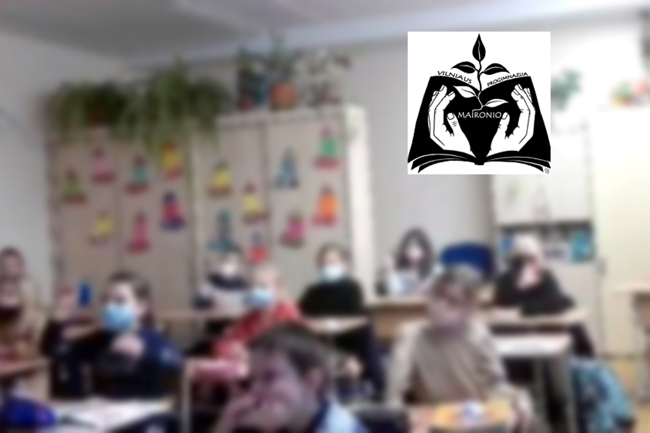 Mokiniai klasėje klausosi pamokėlės apie Kreivąją pilį. Nuotraukos dešiniame kampe Viniaus Maironio progimnazijos logotipas.