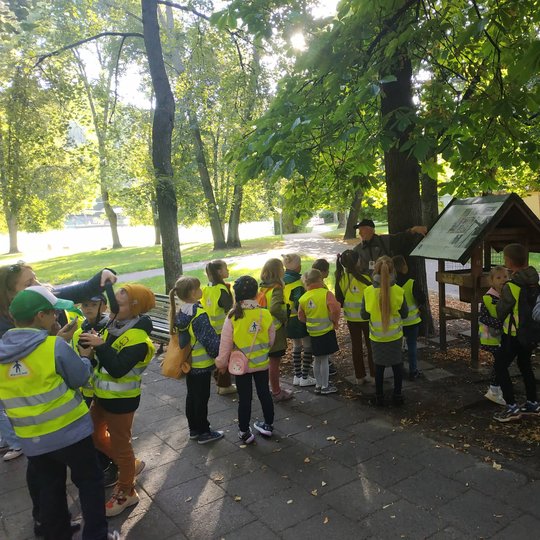 Edukatorius Stasys pasakoja apie paukštukus šalia lesyklėlės Vilniaus pilių parke.