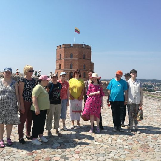 Ekskursijos dalyviai ant Gedimino kalno viršutinės terasos. Jiems už nugarų matosi Gedimino pilis.  