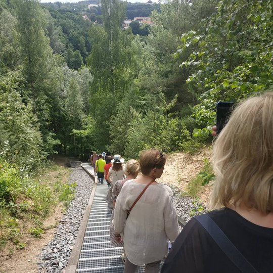 Žmonės eilutė leidžiasi tvarkingais laiptais nuo Bekešo kalno. 