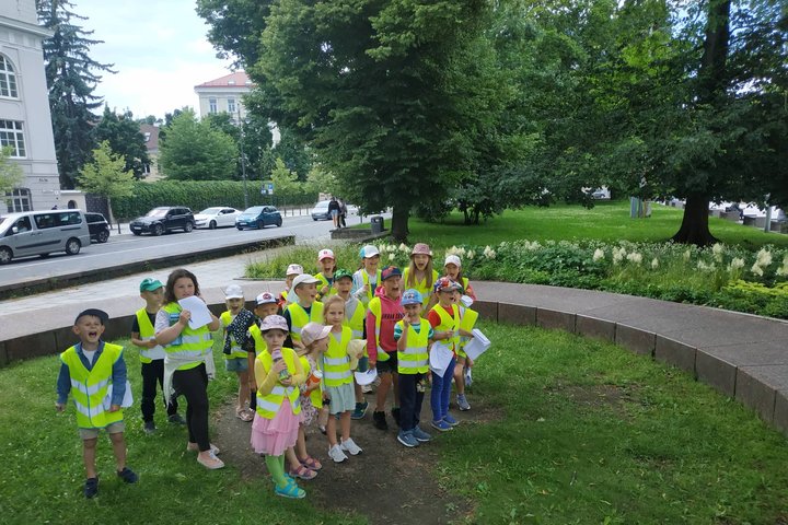 Vaikai su geltonomis atšvaitinėmis liemenėmis šaukia pietinio bokšto pamatų centre. 