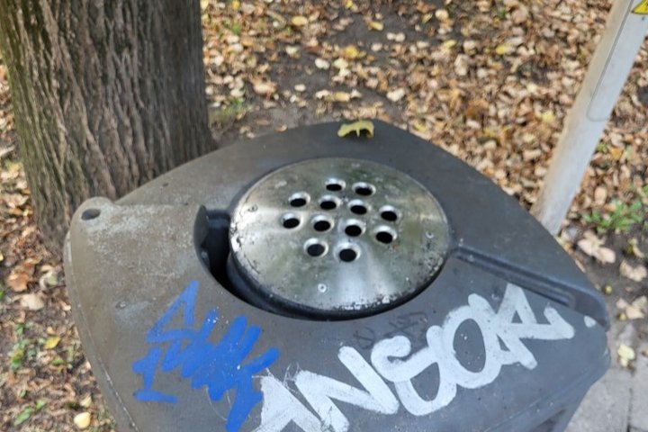 Graffiti išpaišyta šiukšlių dėžė.