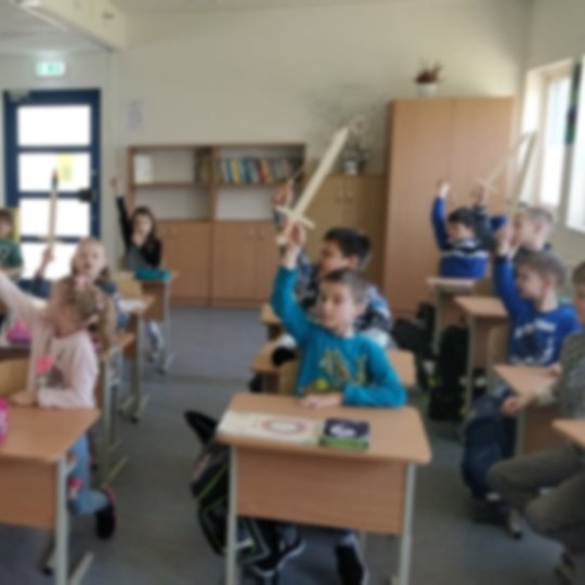 Antrokai klasėje, iškėlę medinius kalavijus į viršų.