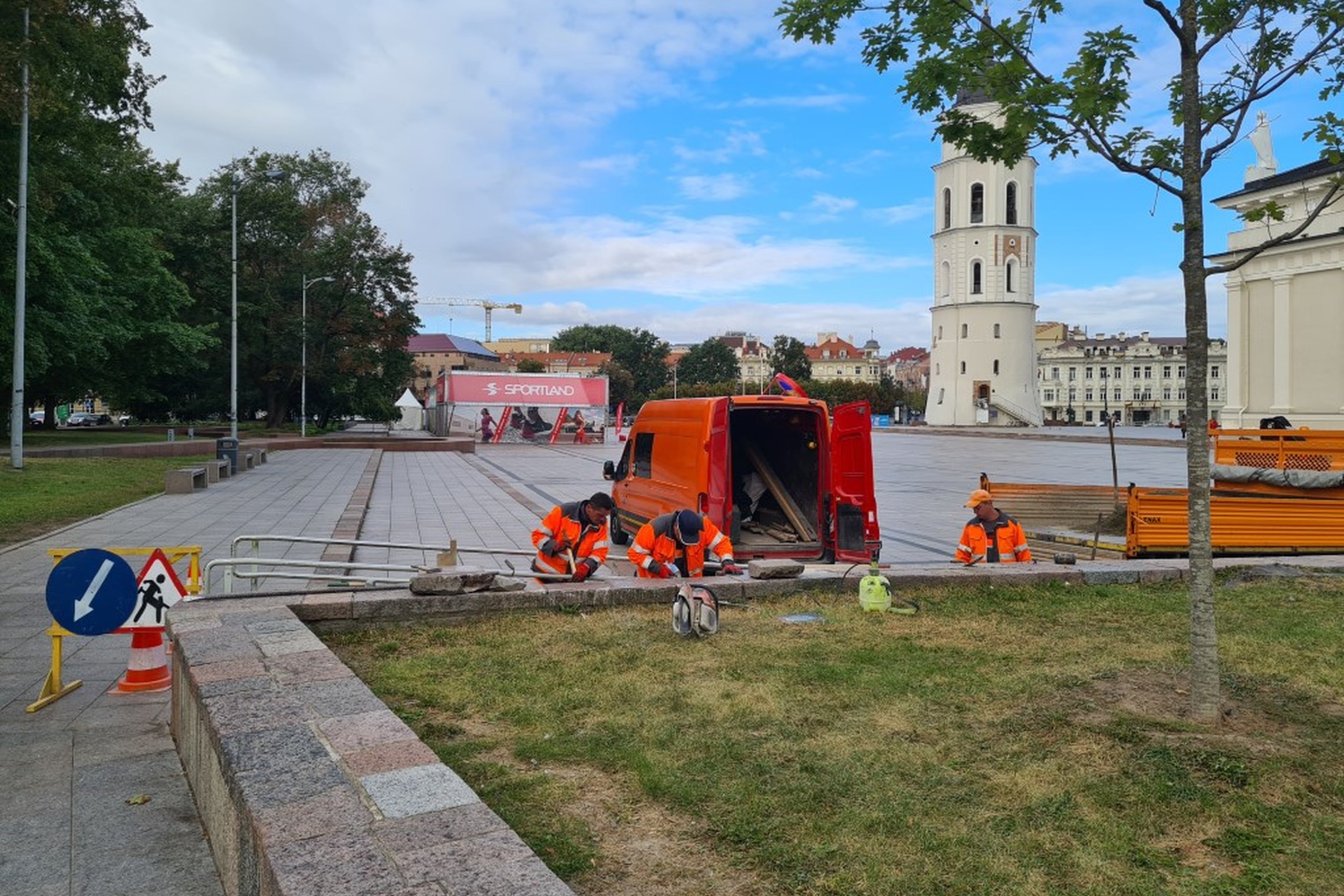 UAB „Grinda“ darbuotojai tvarko atraminę sienutę. Jiems už nugarų Katedros aikštė, matosi varpinės bokštas.