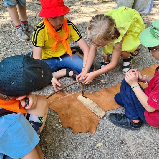Vaikai gavo pabandyti kurti ugnį be degtukų - su pagaliuku ir lentele.