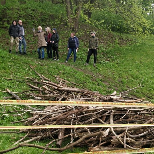 Vidaus reikalų ministerijos darbuotojai stovi ant tako. Nuotraukos apačioje šakų kruva.