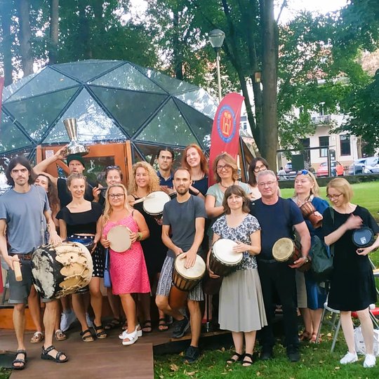 Būgnų rato dalyviniai pozuoja bendrai nuotraukai priešais Vilniaus pilių kupolą.