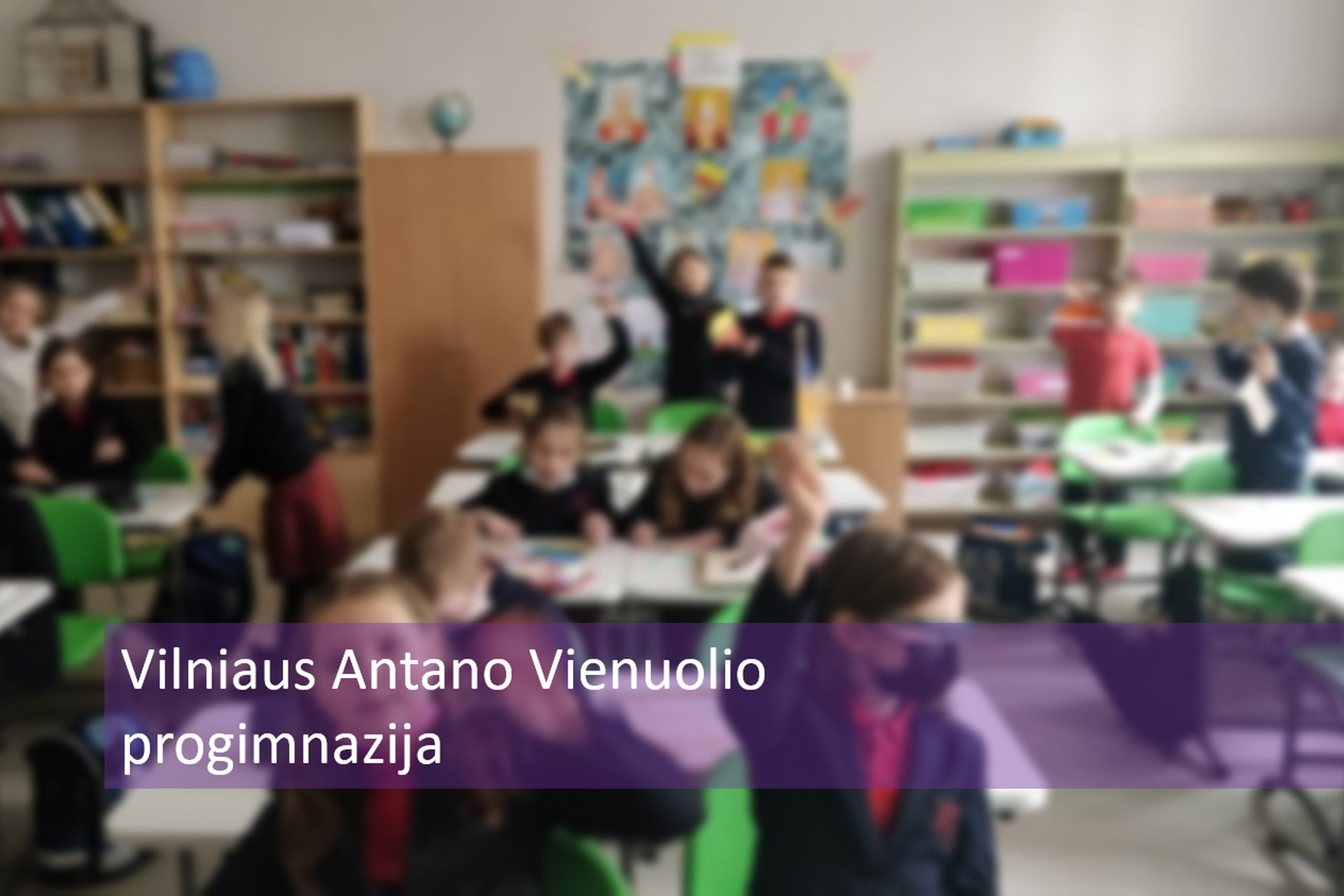 Mokiniai klasėje. Nuotraukos priekyje parašyta "Vilniaus Antano Vienuolio progimnazija".