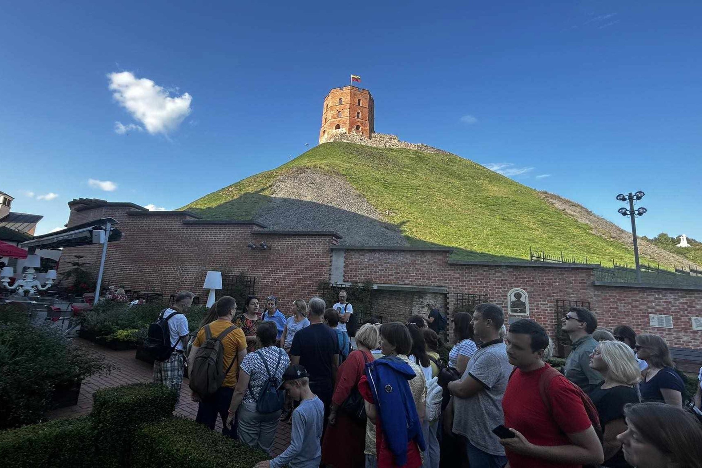 Grupė ekskursijos dalyvių Gedimino pilies kalno papėdėje, dabartiniame Bonos Sforcos sodelyje.
