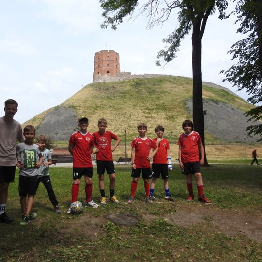Grupė jaunųjų futbolininkų Pilių parke. Fone matosi Gedimino pilis.